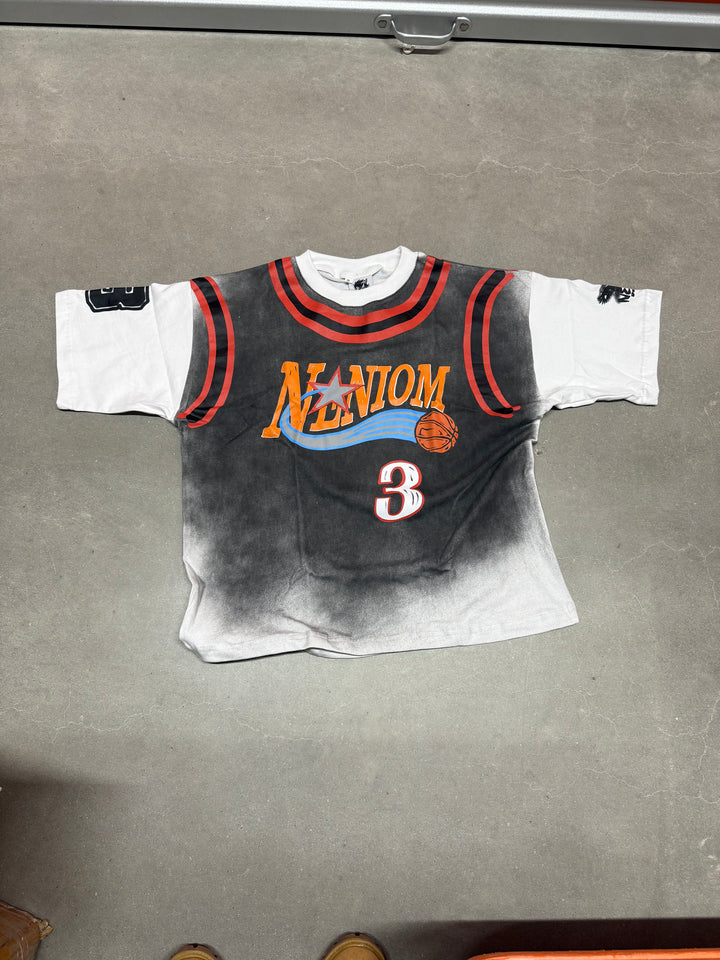 Black and white t-shirt with colorful graphics on a gray surface