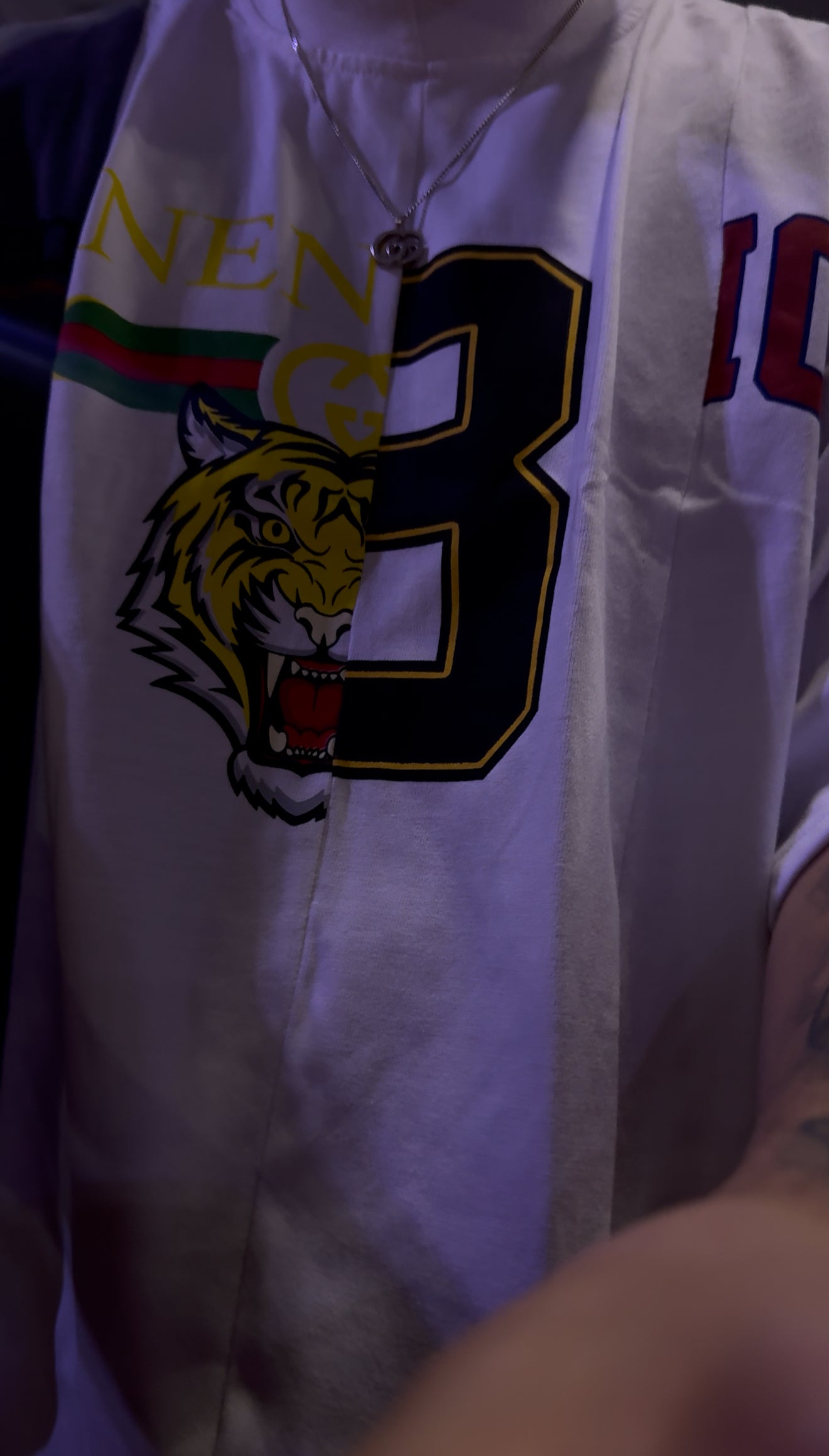 White sports jersey with tiger emblem and number 8 on a dark background