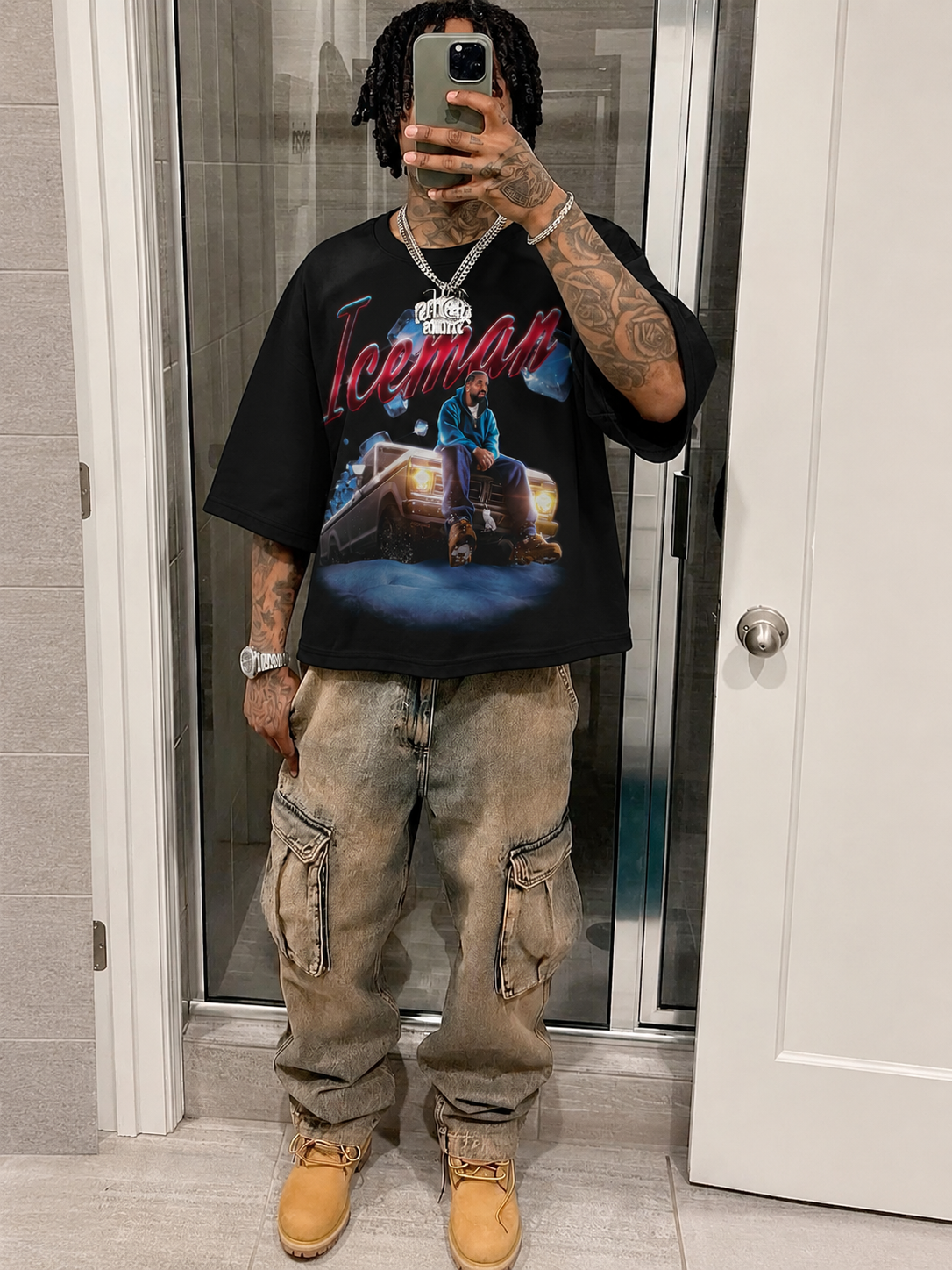 Person wearing a black t-shirt with a graphic design and beige pants, standing in a room. Drake Iceman Art Boxy Shirt Vintage Bootleg Streetwear Oversized Graphic Tee