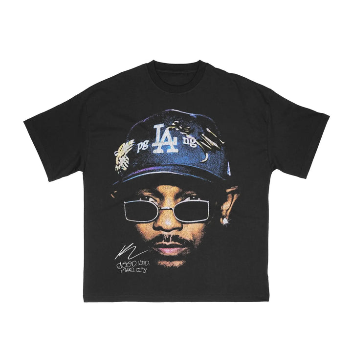 Black t-shirt with a graphic of a person wearing a cap and sunglasses on a white background. kendrick lamar shirt