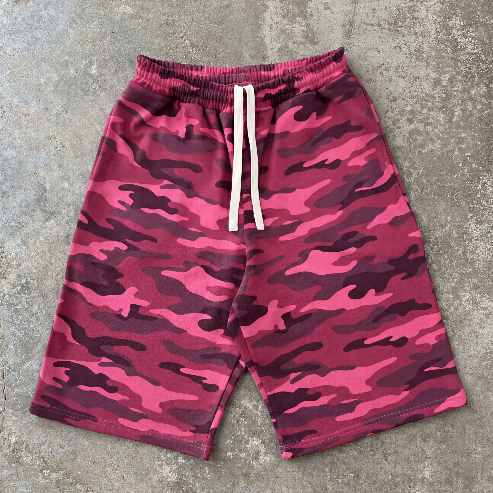 Pink camouflage shorts on a gray concrete surface