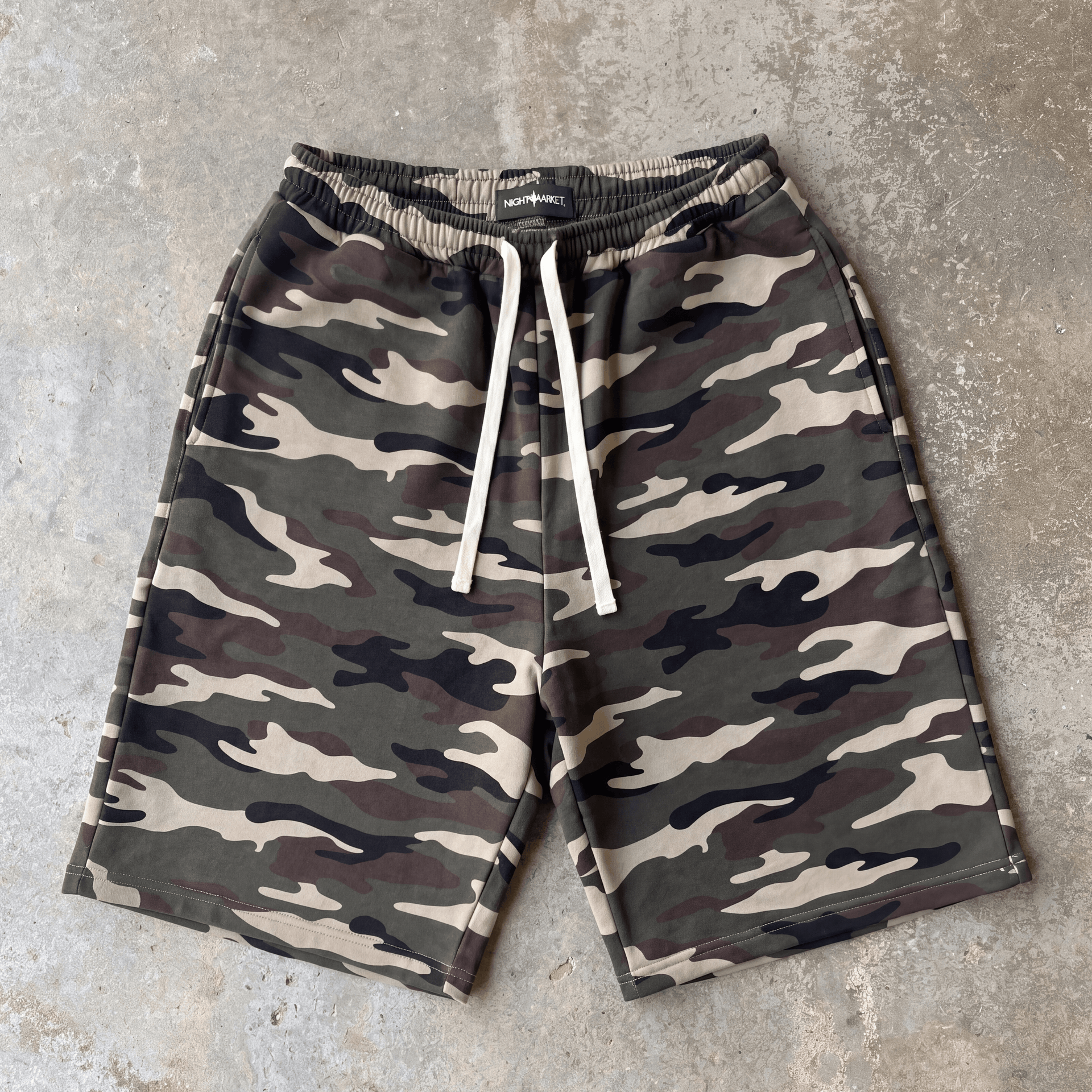 Camouflage shorts with drawstring on a concrete surface